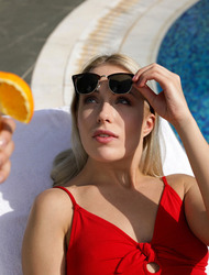 Stunning in a bathing suit and high heeled sandals, Angelika Grays gets cozy by the swimming pool for a tanning session